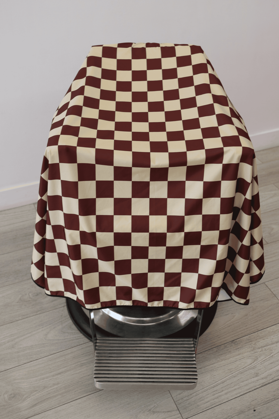 top view of Check Cape showcasing the burgundy and tan checker pattern of the cape.