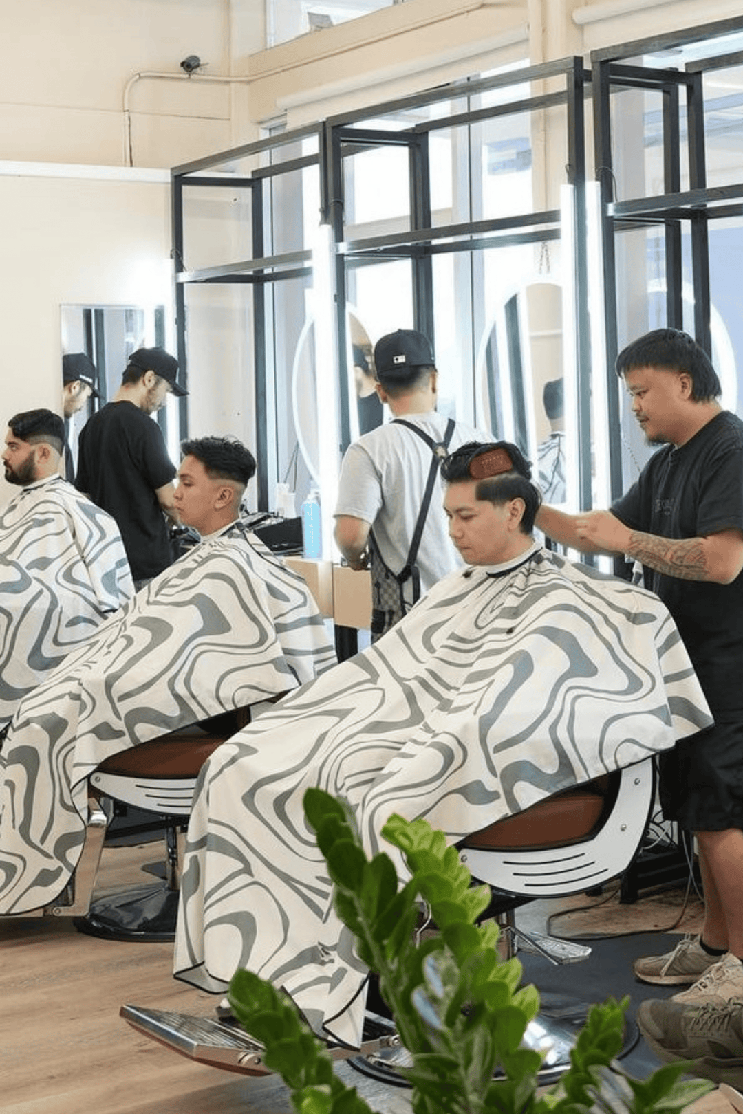 Three barbers with three customers all wearing the Aurora Barber Cape by High Top Capes
