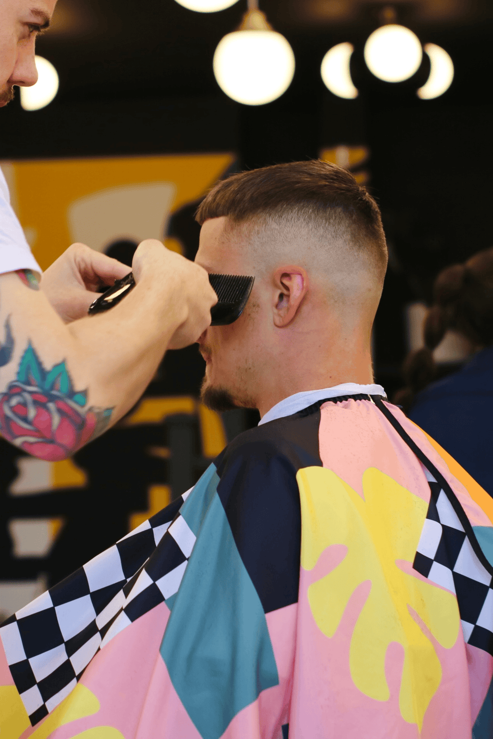 Century Cape draped over customer while barber cuts hair with comb and clippers